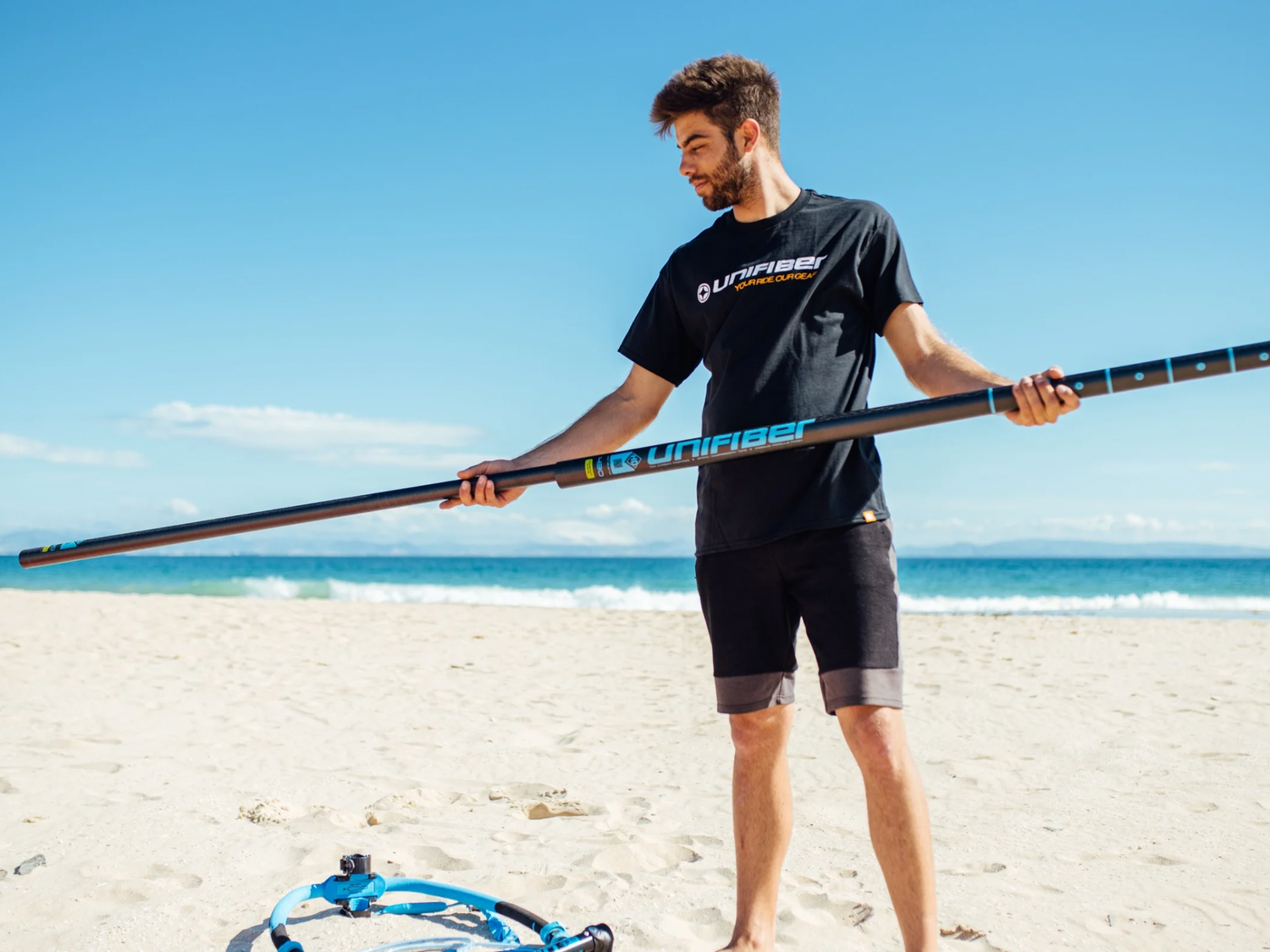Windsurfer putting his windsurf mast together on the beach