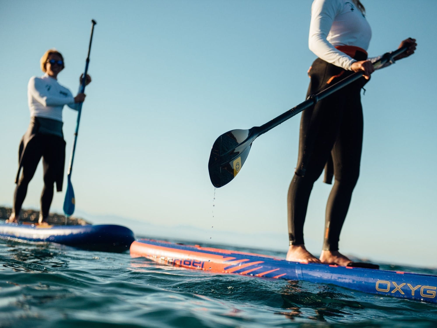 Stand up paddlers standing on SUP inflatable boards and using Unifiber paddle
