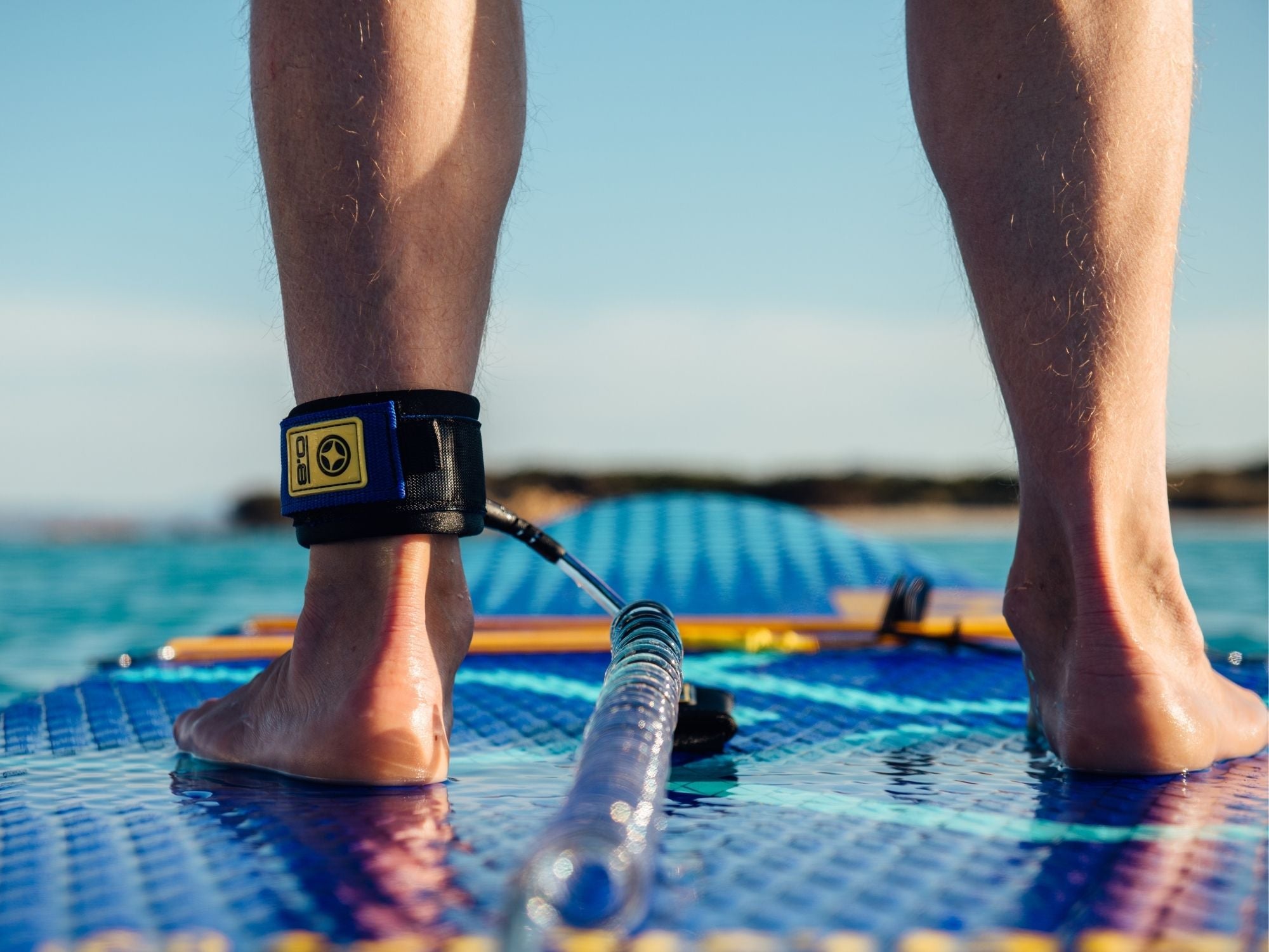 Close up of rider's legs on an inflatable stand up paddle on the water