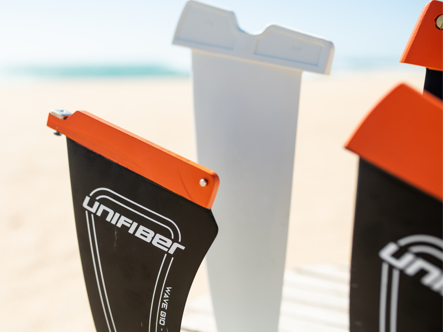 Close up of 3 Unifiber windsurf fins on the beach