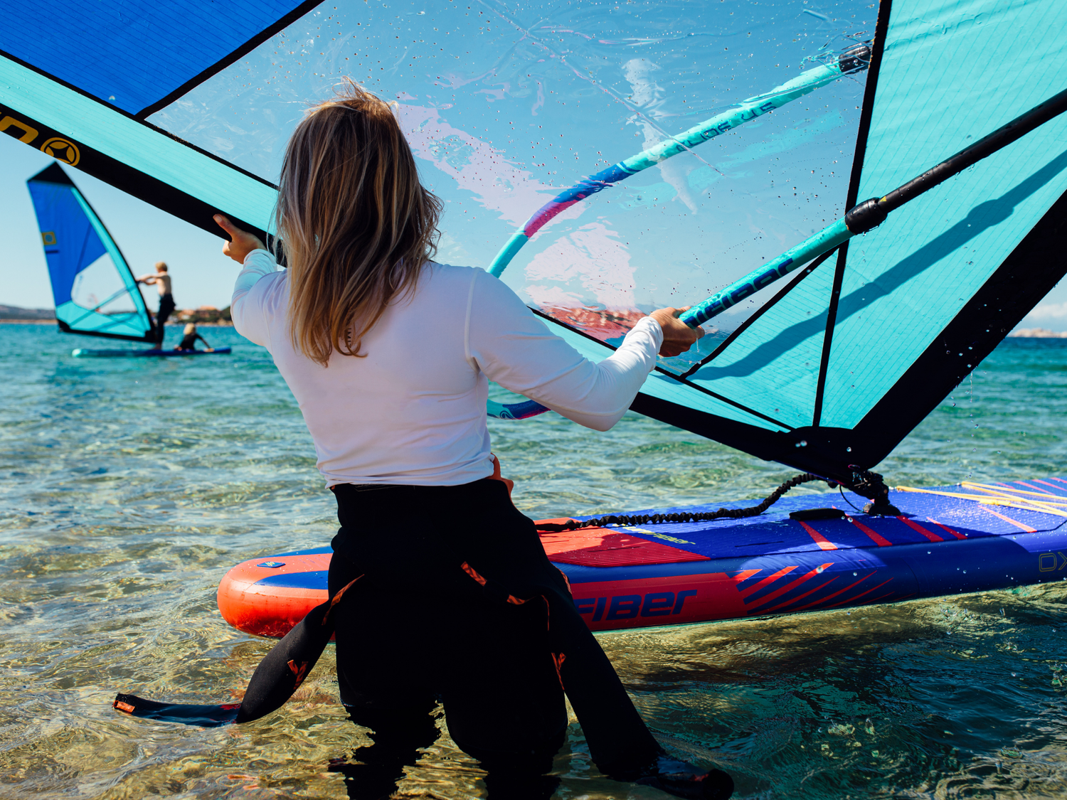 Female windsurfer holding Unifiber complete rig on the water