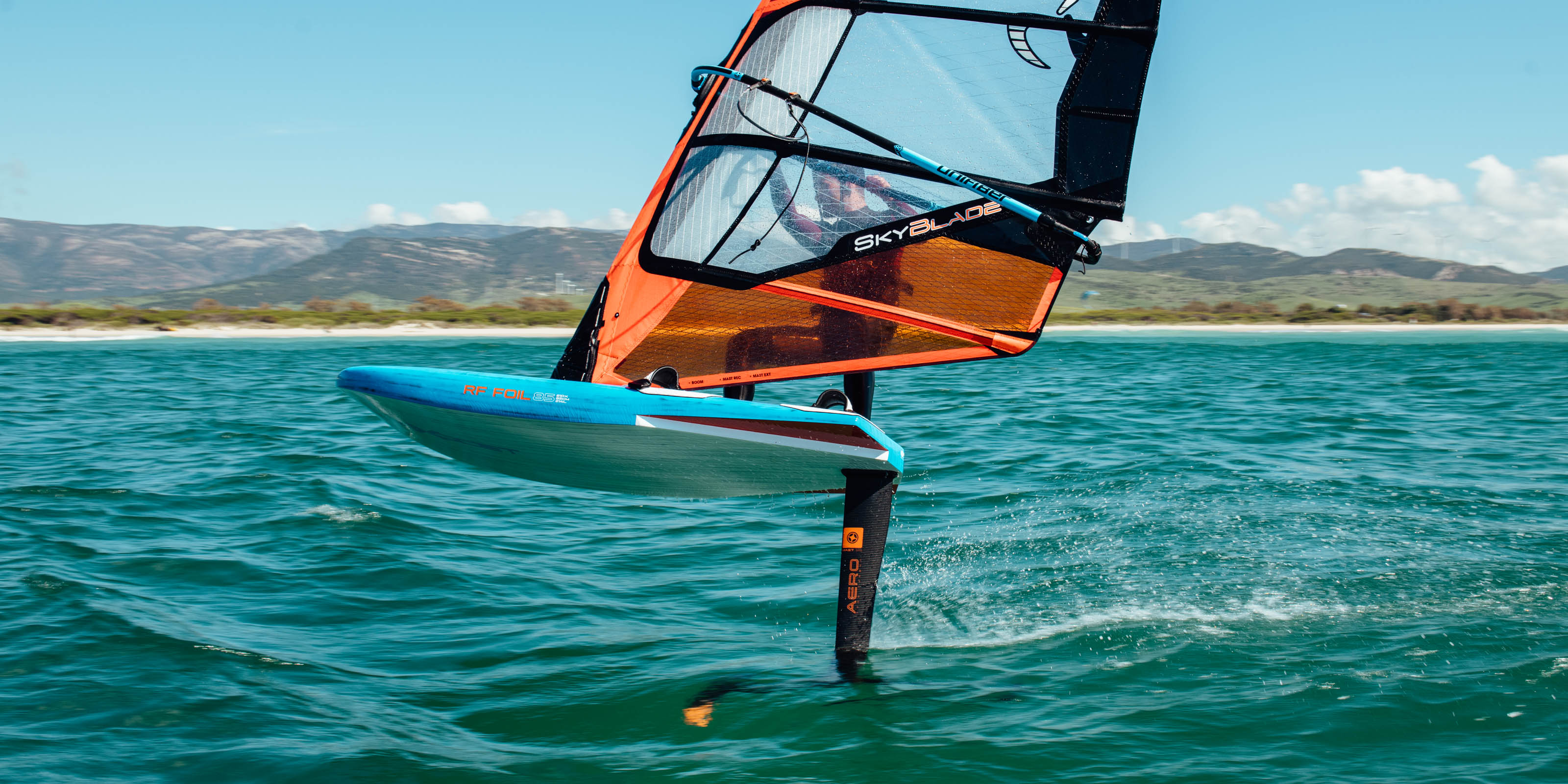 windsurfer fyling above the water on a windfoil board