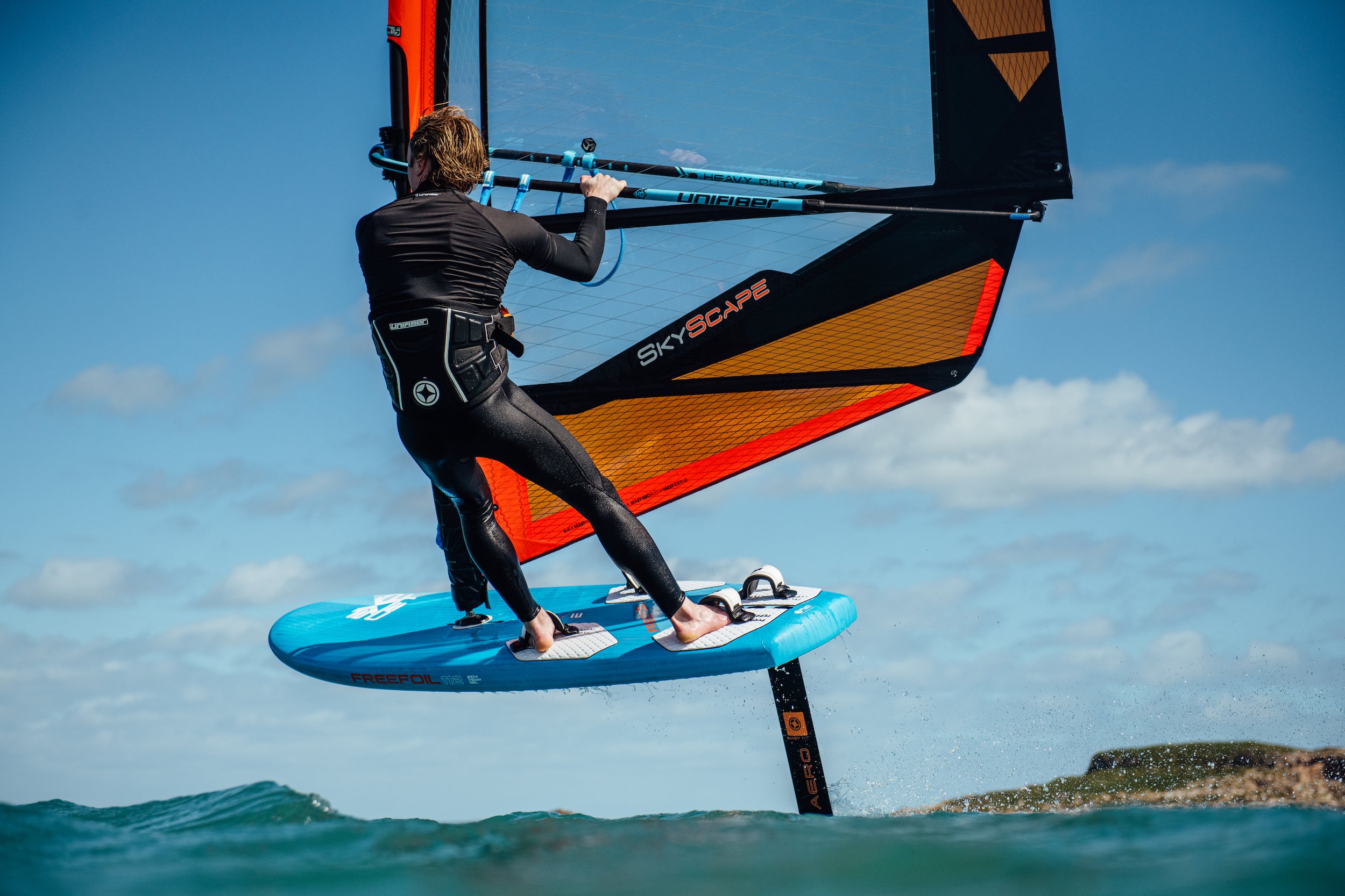 Advanced windsurf harness with Skyscape sail from loftsail, highlighting freedom of movement during foiling