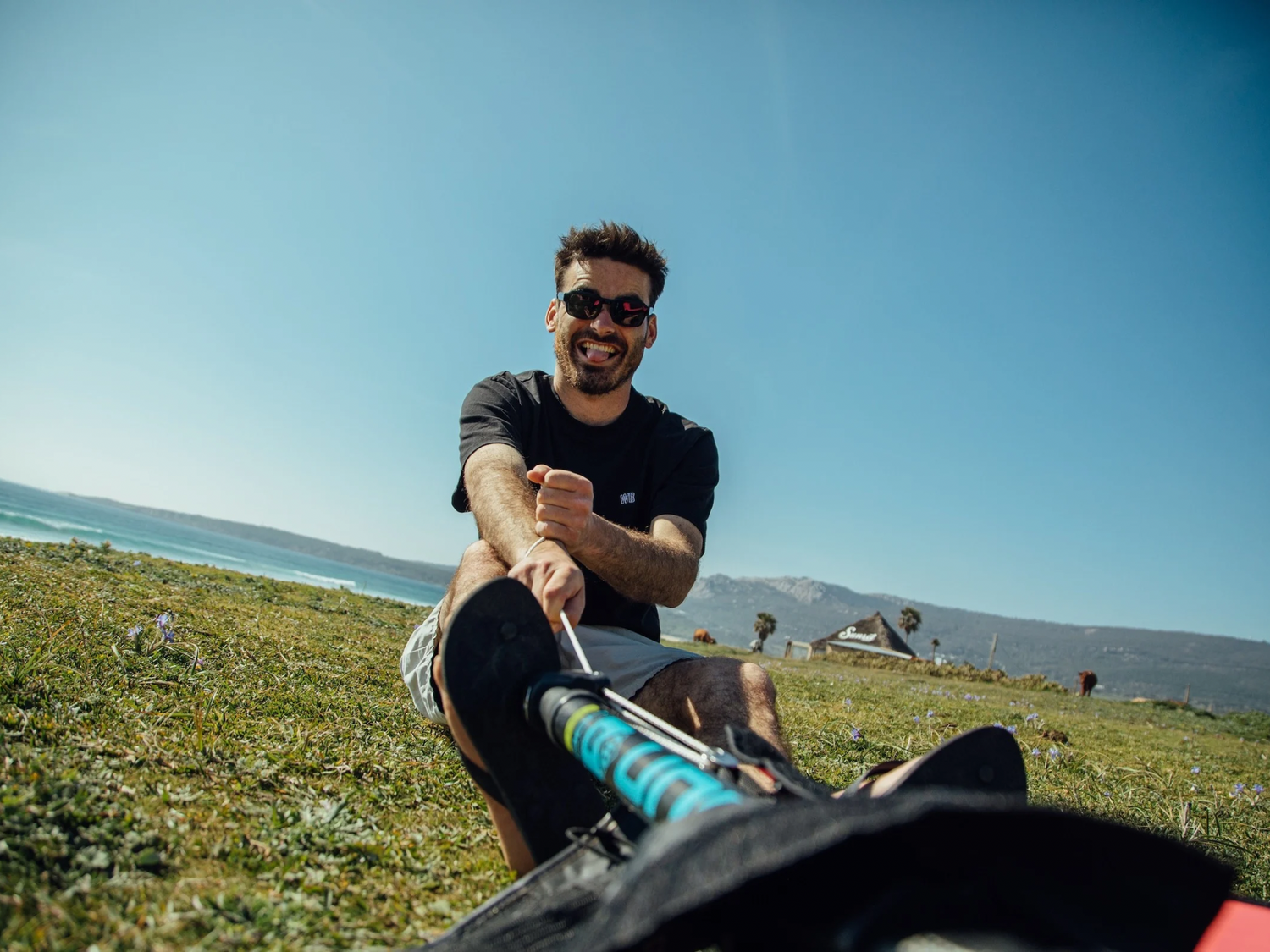 Windsurfer rigging his sail on Unifiber black and blue mast