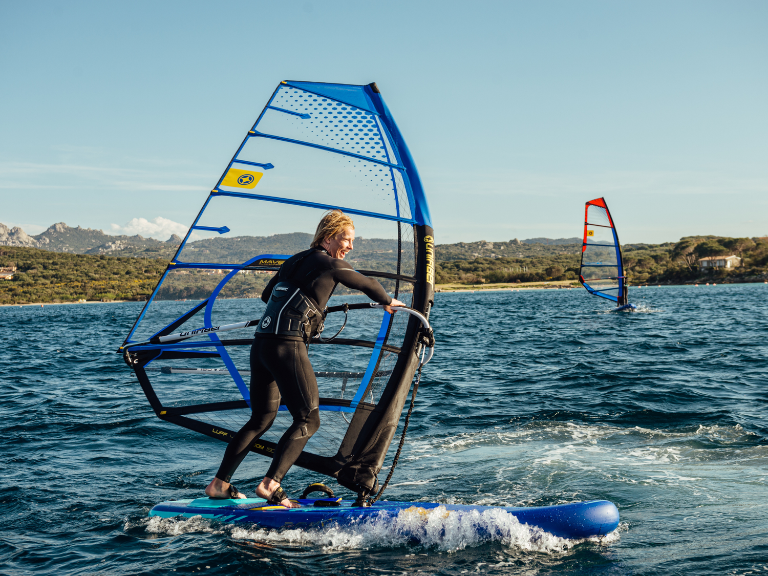 Unifiber Skywatch anemometer in action: Windsurfer navigates blue waters using precise wind measurement tech for optimal sail selection. 