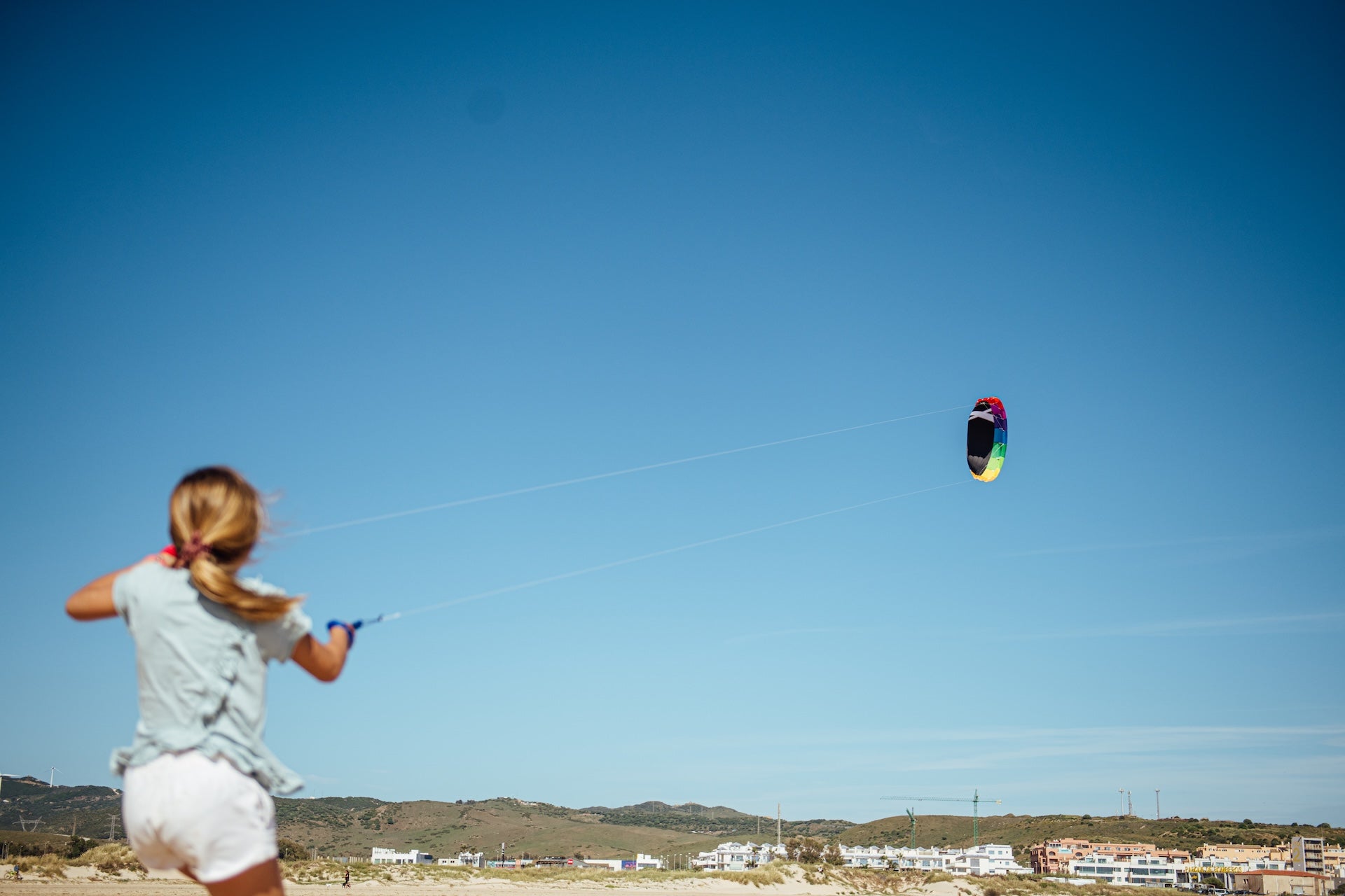 a kid playing with kite on the beach 