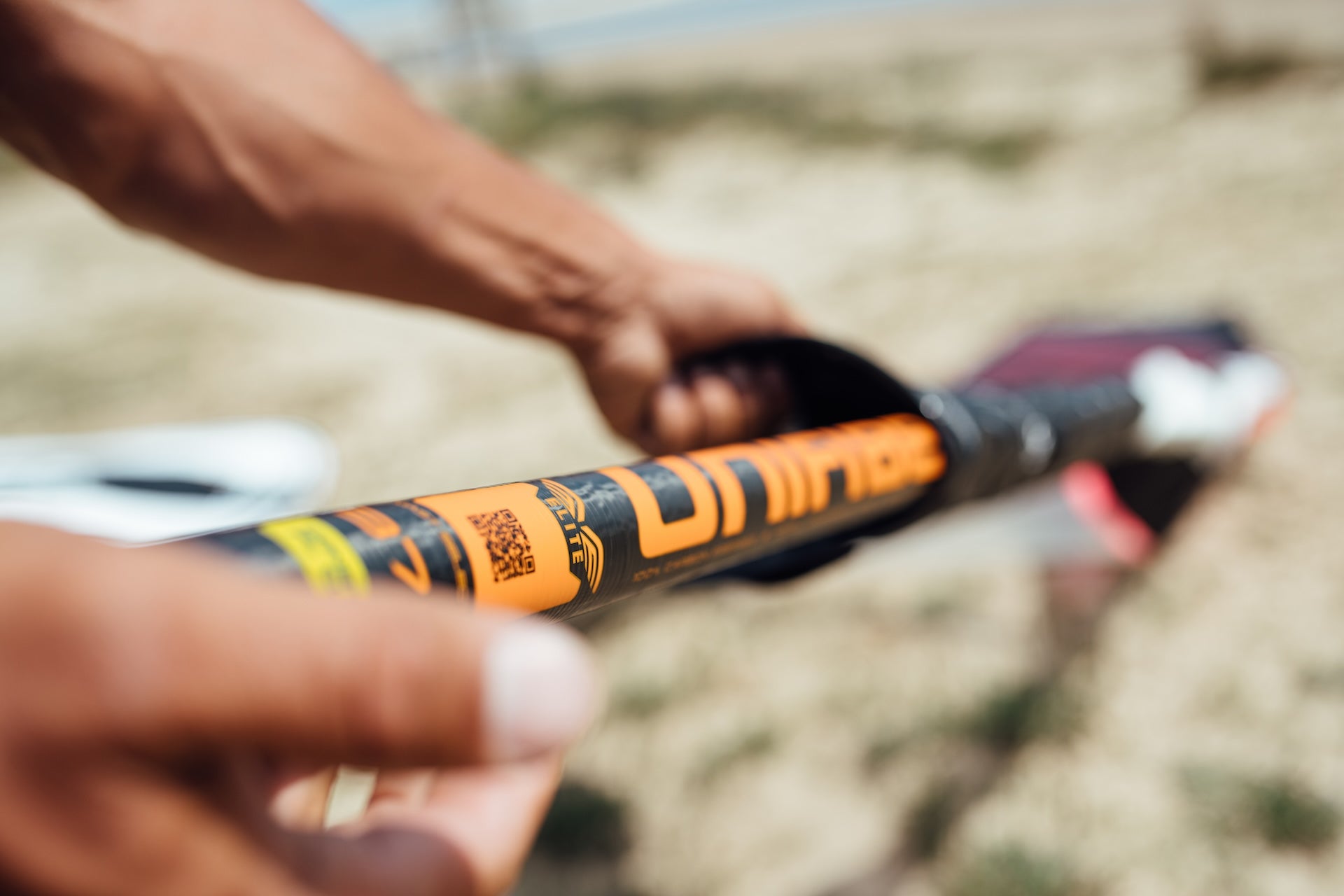 close up image of windsurf rdm mast with orange Unifiber logo. the mast is on the beach and we can see the junction