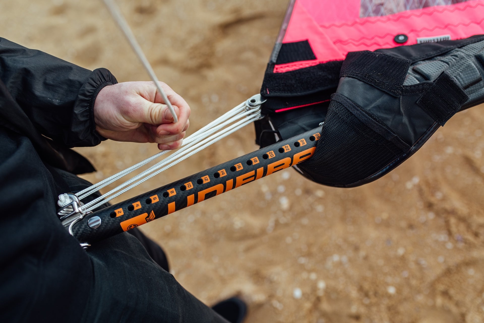 Someone rigging a windsurf sail using the downhaul system of the extension with dynema rope and pulley