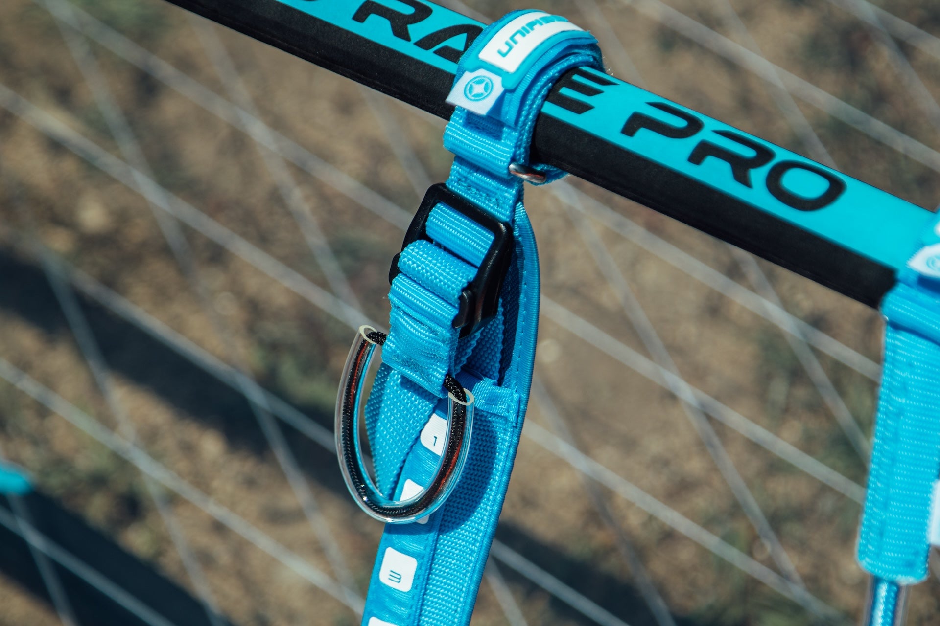 The image shows a close-up of a windsurfing harness line. There's a boom  with what appears to be a Unifiber logo (the light blue vertical tube with "UNIFIBER" printed on it).
